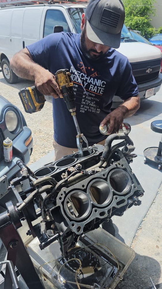 Technician tightening bolts on an engine in the shop